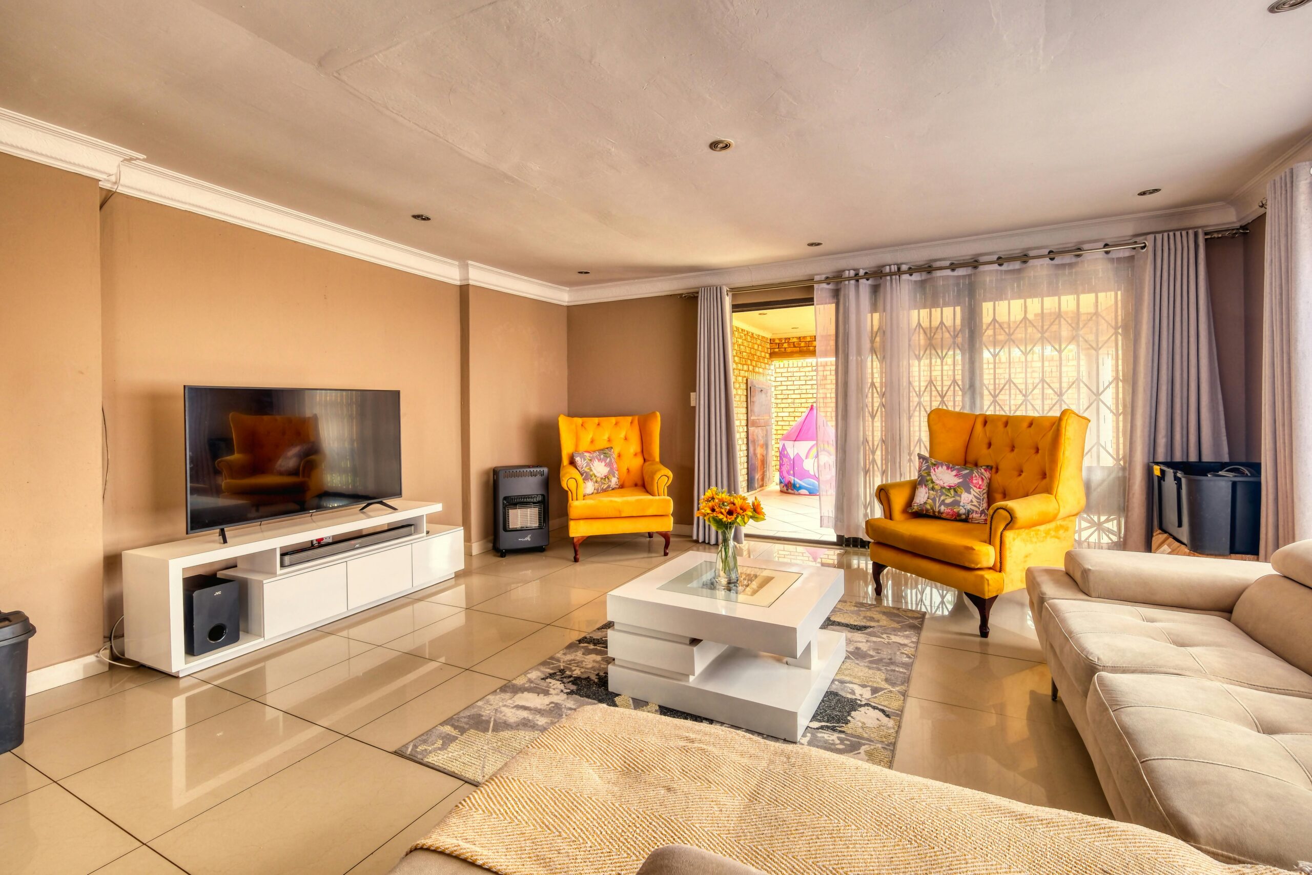Spacious and stylish living room featuring yellow armchairs and elegant design.